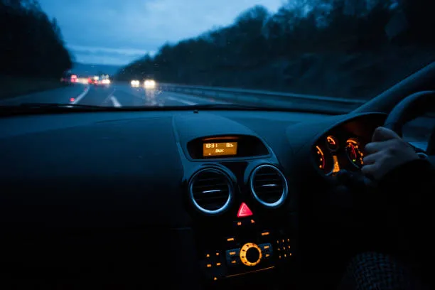 The view from the driver’s seat at dusk, dashboard lit